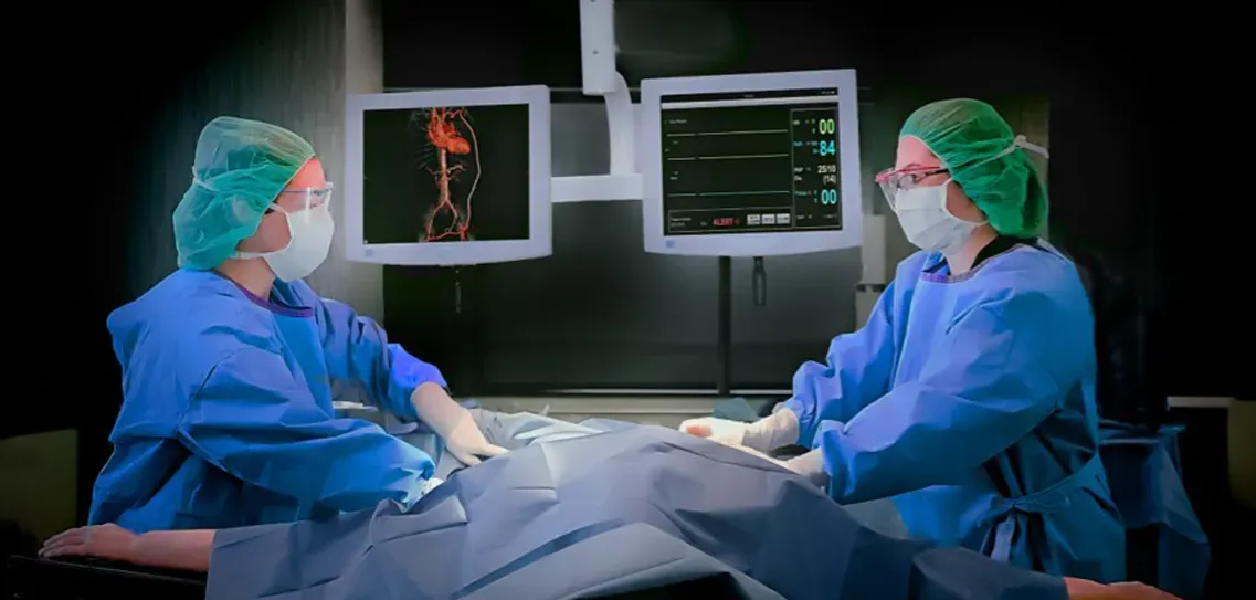 A surgical team at work beside imaging monitors